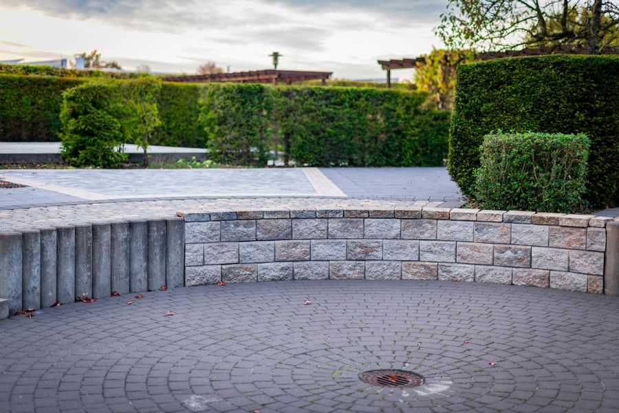 Gartenanlage mit Natursteinmauer, Sitzplatz und Formhecken