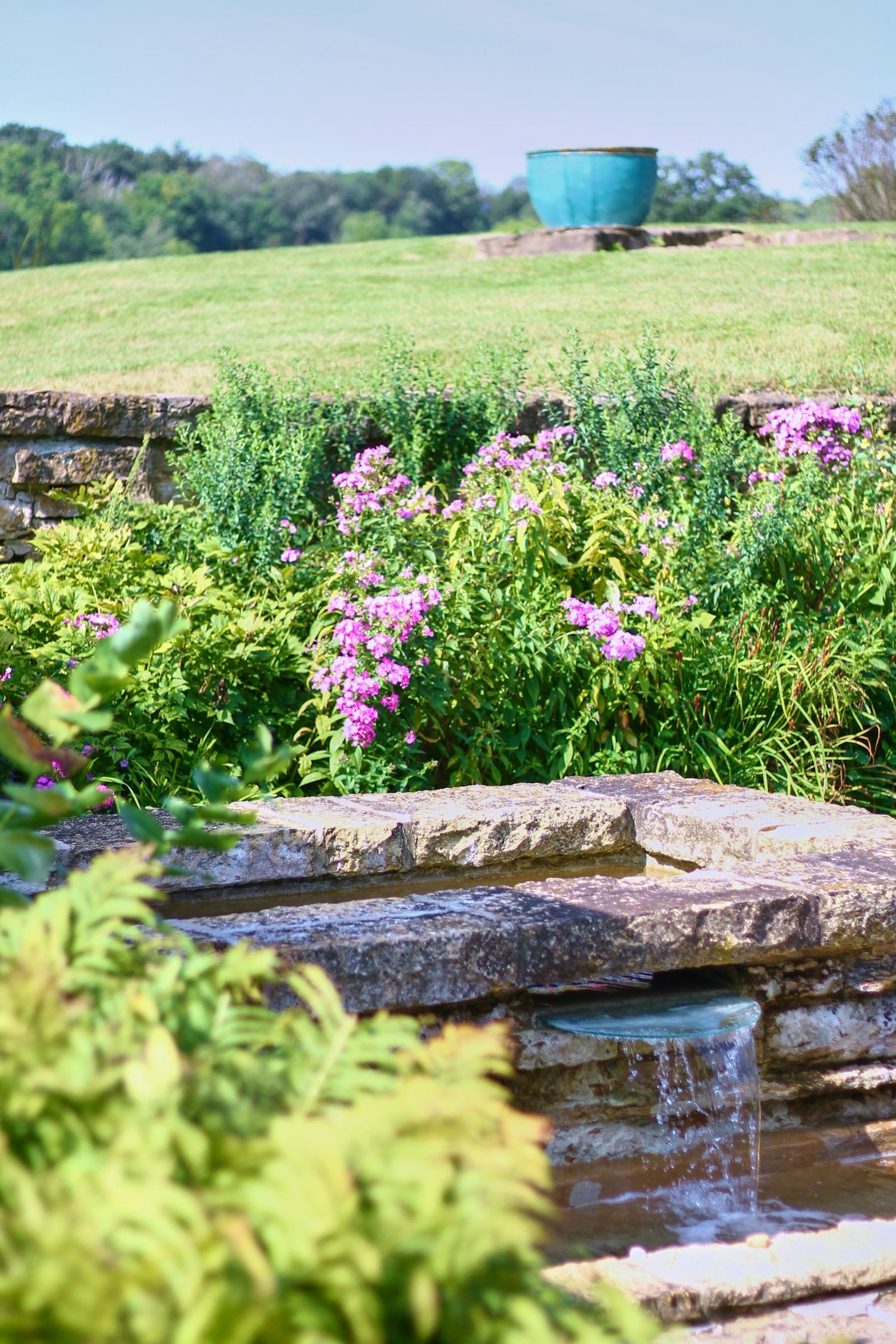 Wasserbecken aus Naturstein mit Staudenbepflanzung